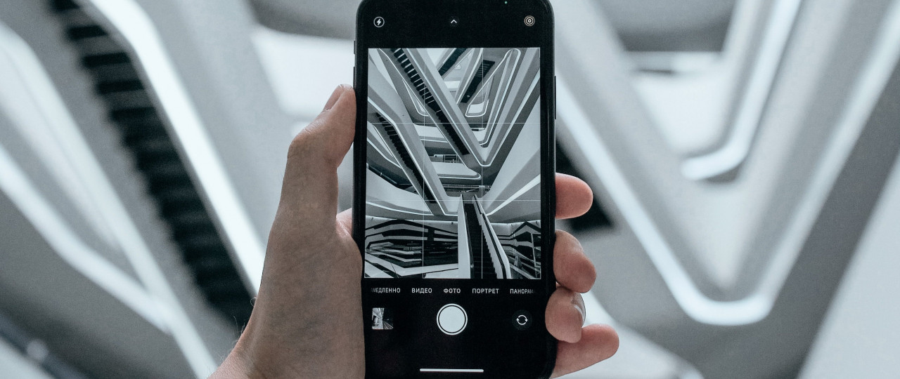 Image of a photo being taken on an iPhone. The iPhone is capturing the abstract architectural structure of stairs.