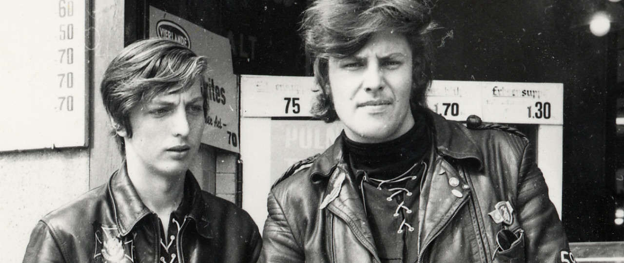 Two young men posing in leather outfits.