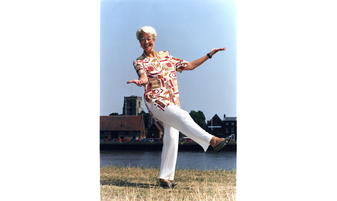 Peggy Spencer dancing on a riverside. This image is part of her archives.